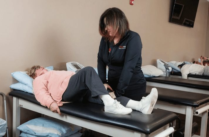 A woman sitting on top of a bed with another person.