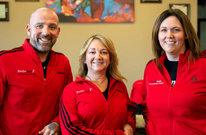 Three people in red jackets posing for a picture.