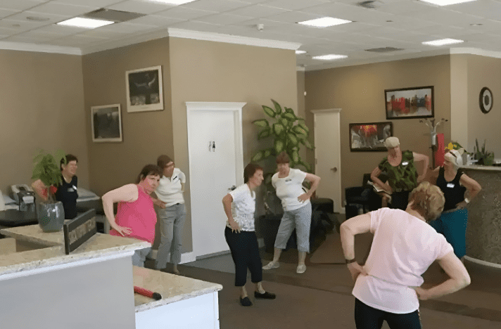 A group of people in a room with some kind of exercise equipment.