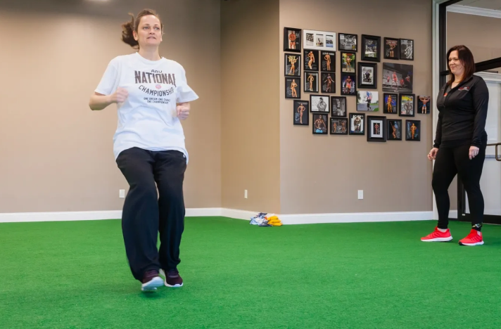 A woman is playing frisbee in the room.