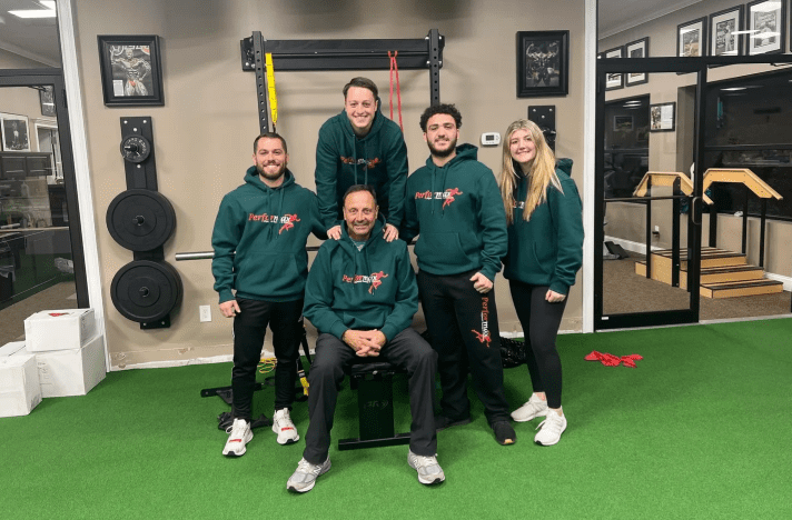 A group of people in green sweatshirts posing for the camera.