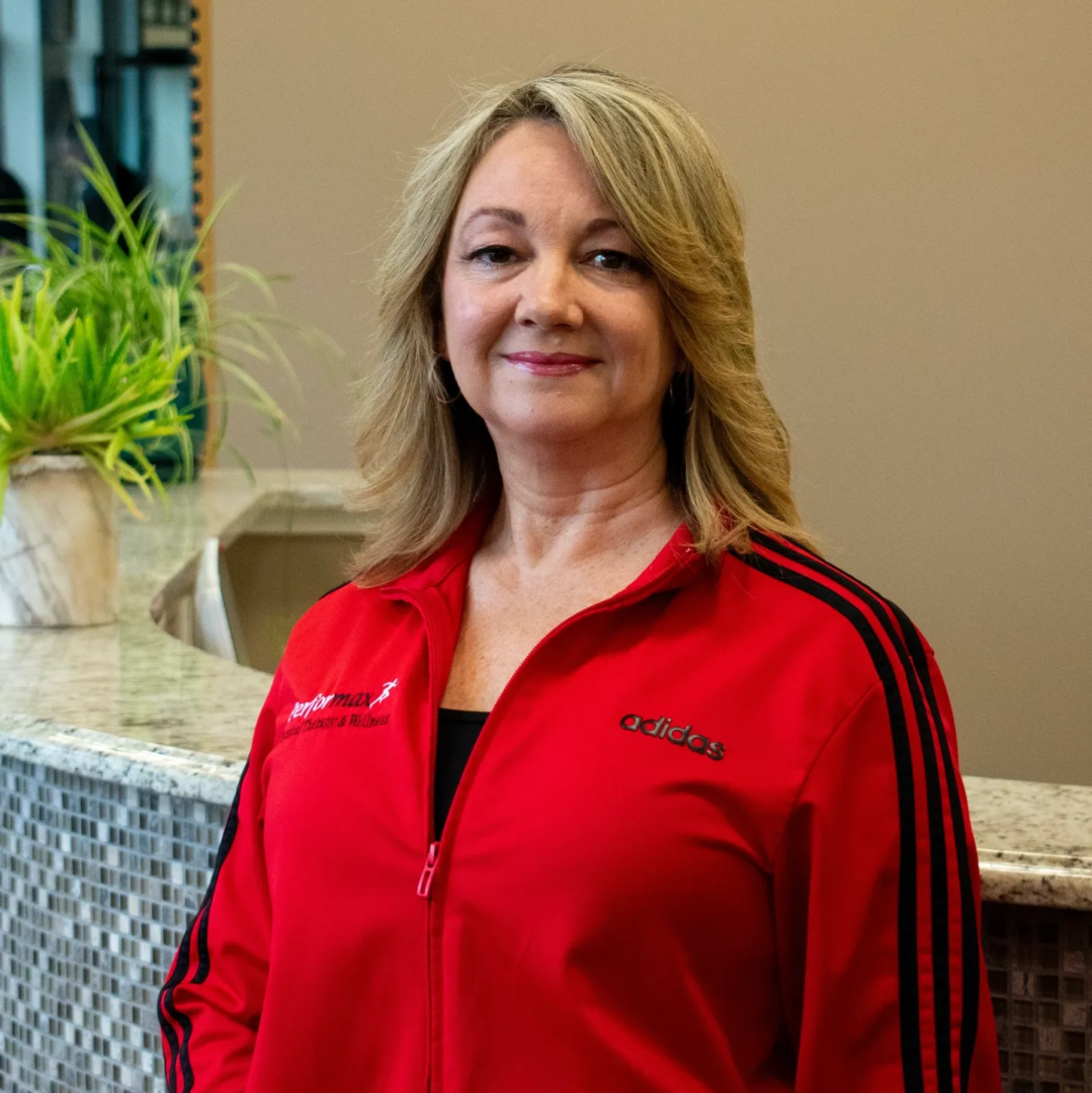 A woman in red jacket standing next to a counter.