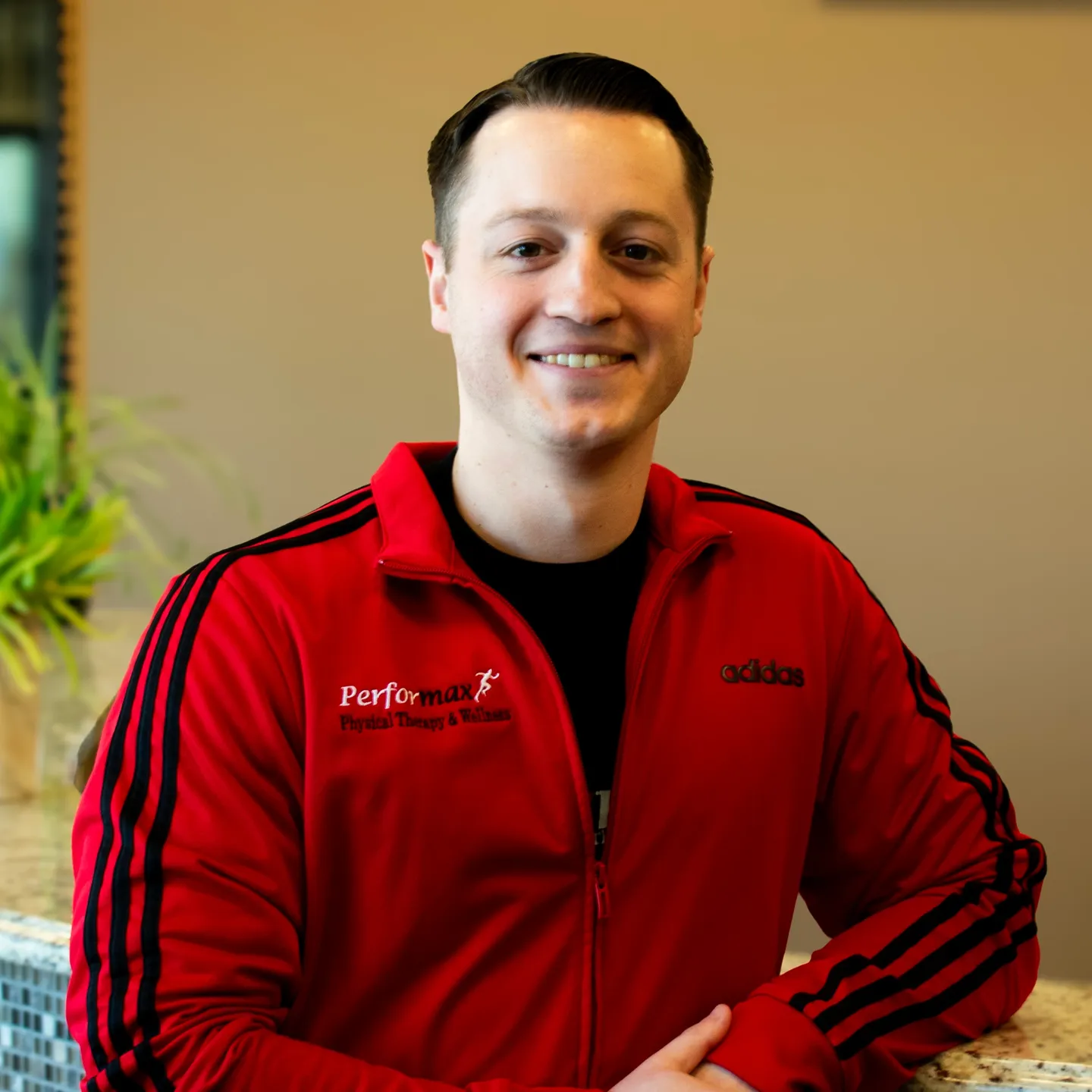 A man in red jacket smiling for the camera.