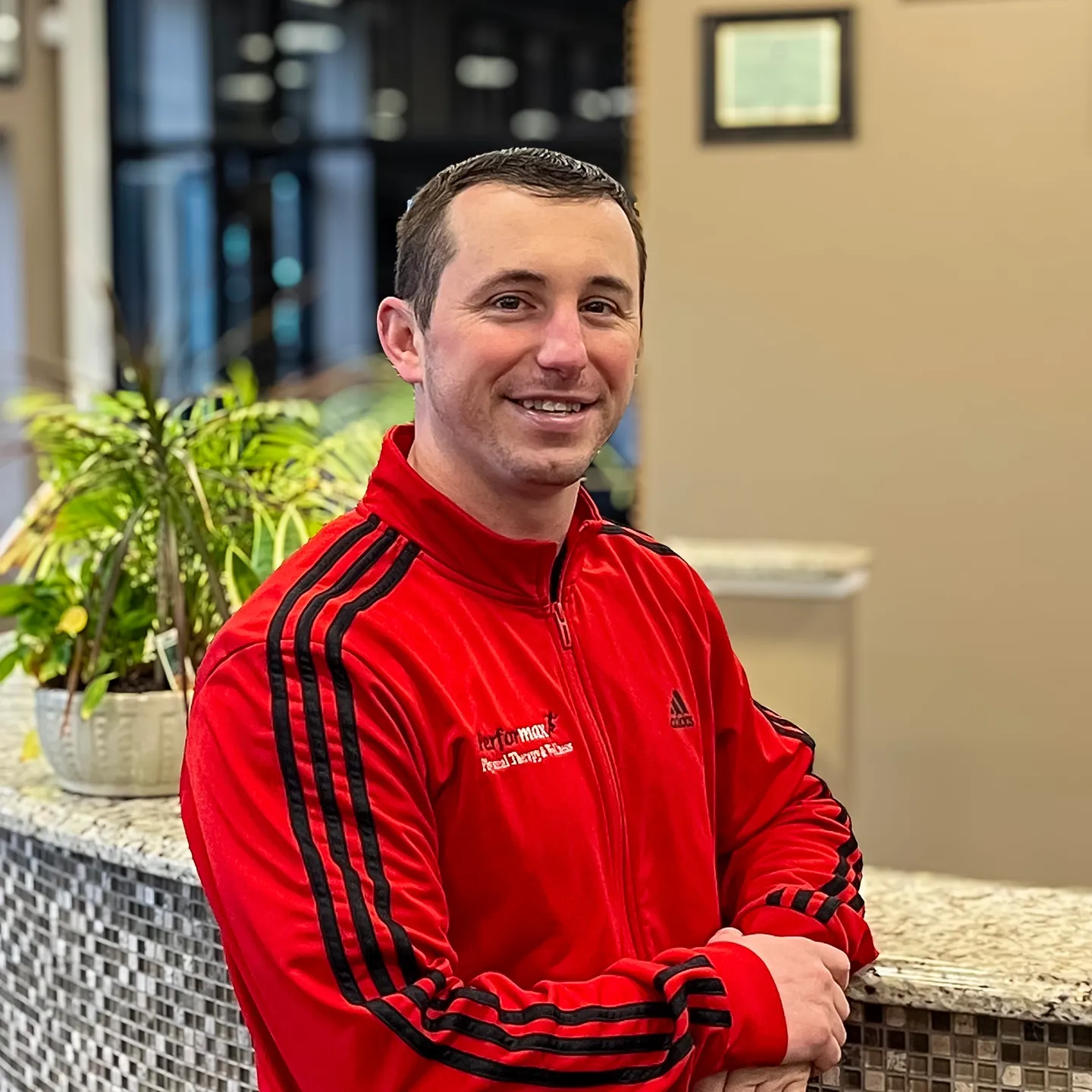 A man in red jacket standing at the counter.