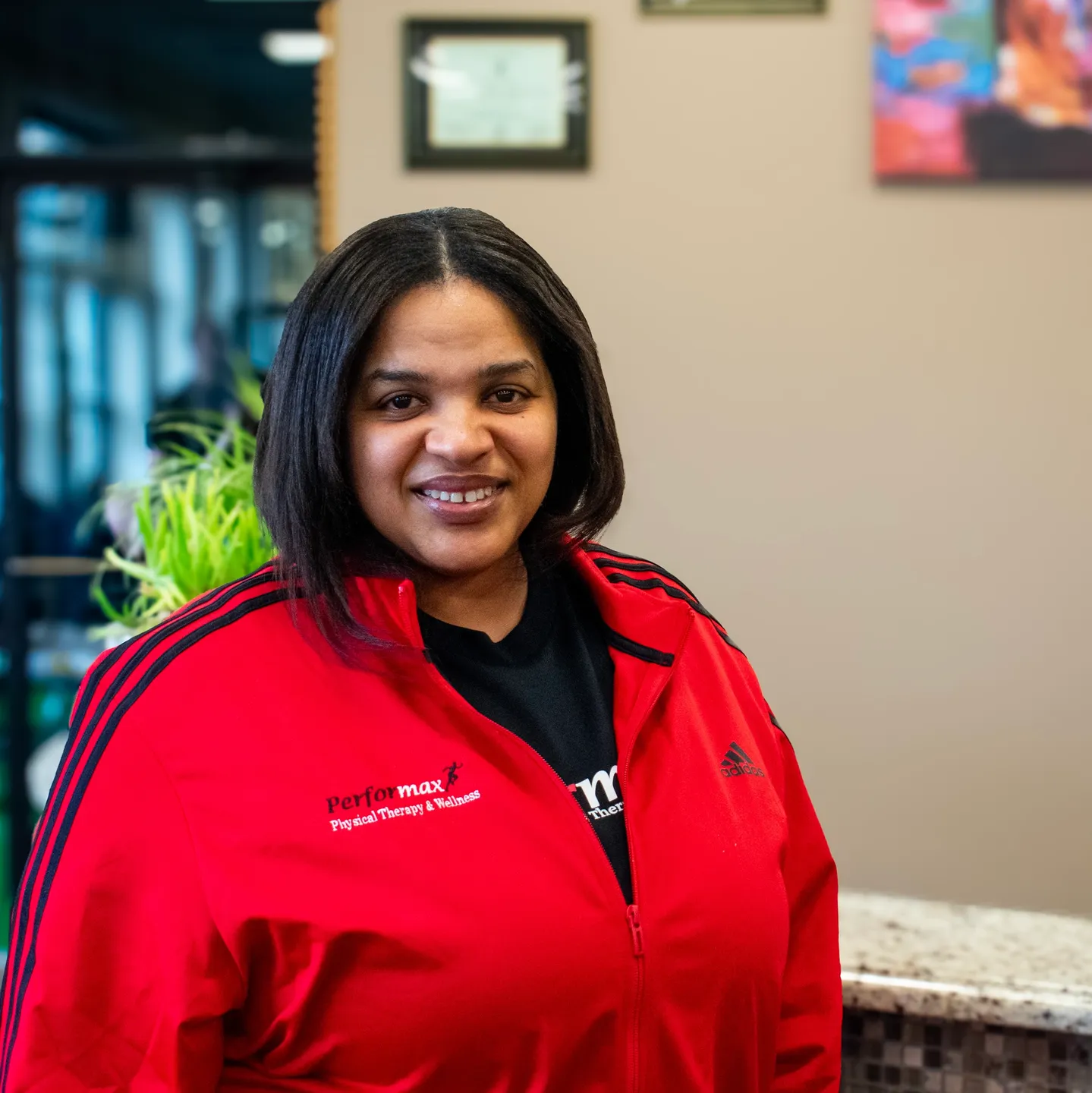 A woman in red jacket standing next to counter.