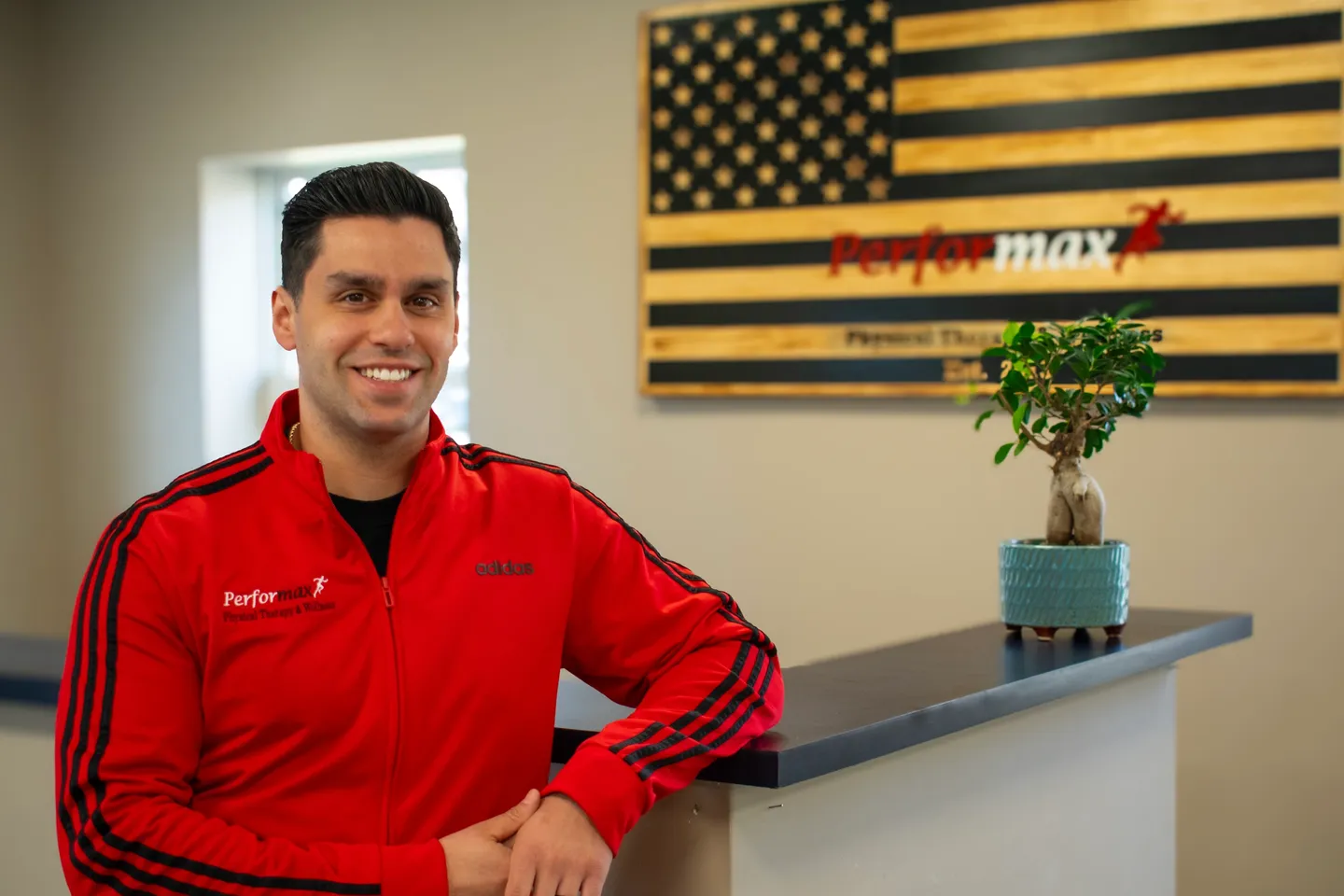 A man in red jacket standing at counter.