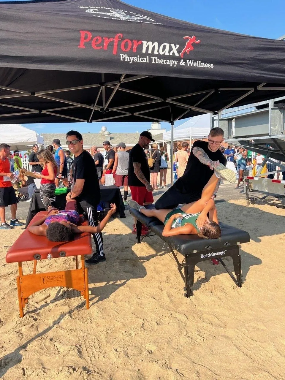 A group of people on the beach with massage tables.