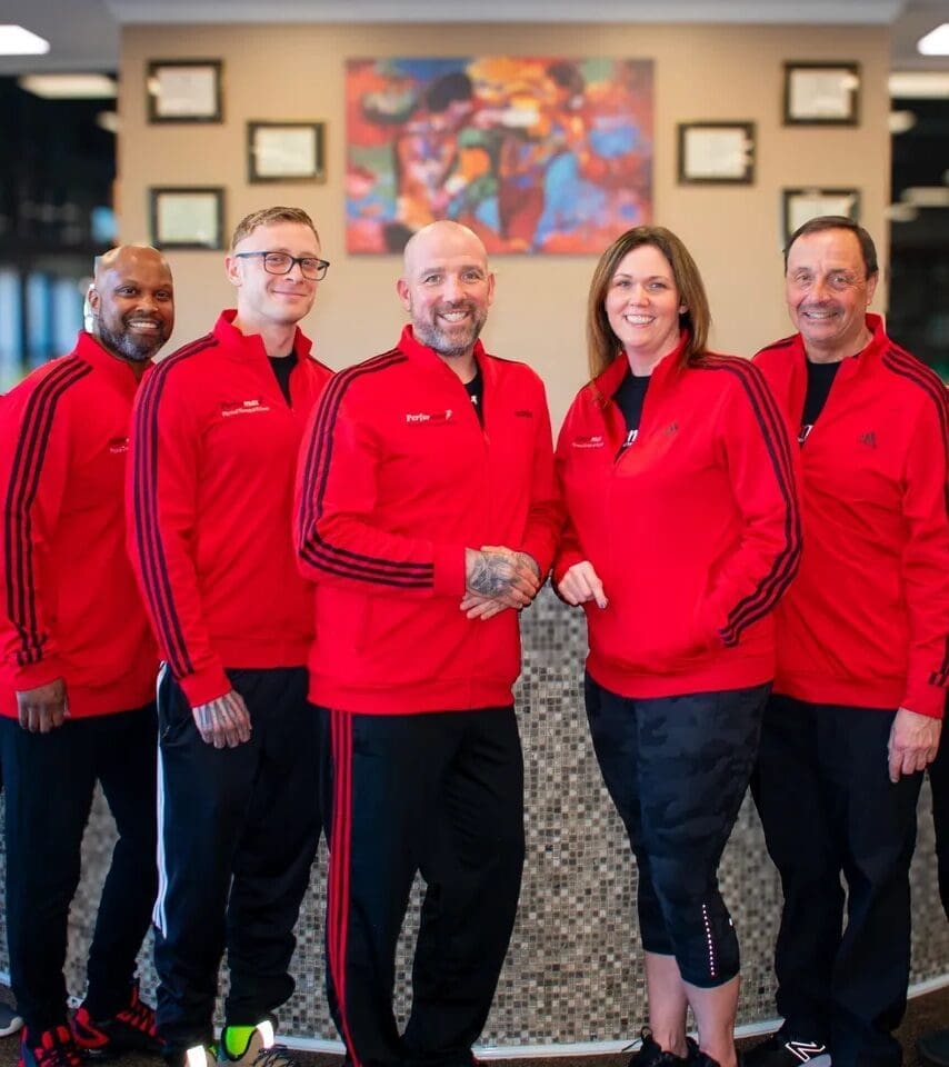 Group wearing matching red jackets, smiling together.